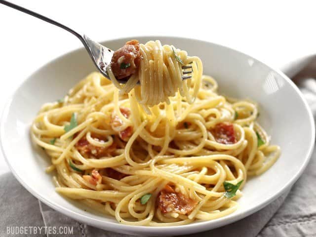 A forkful of Spaghetti Carbonara being lifted out of the bowl