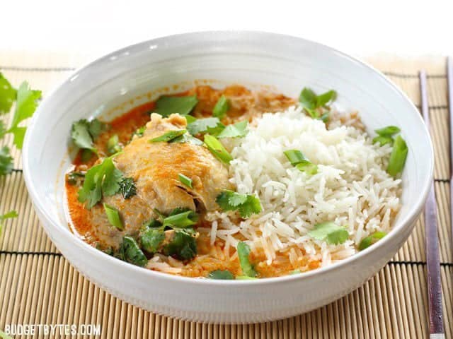 Front view of a bowl full of Thai Coconut Curry Chicken Thighs with jasmine rice and cilantro