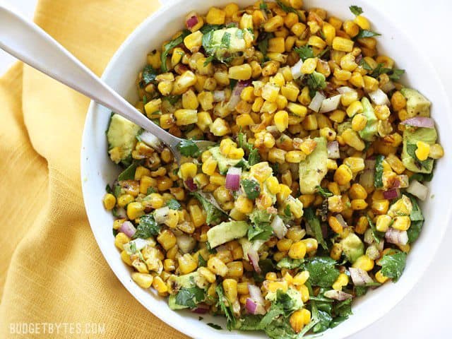 Overhead view of Warm Corn and Avocado Salad with a fork stuck in the side of the bowl