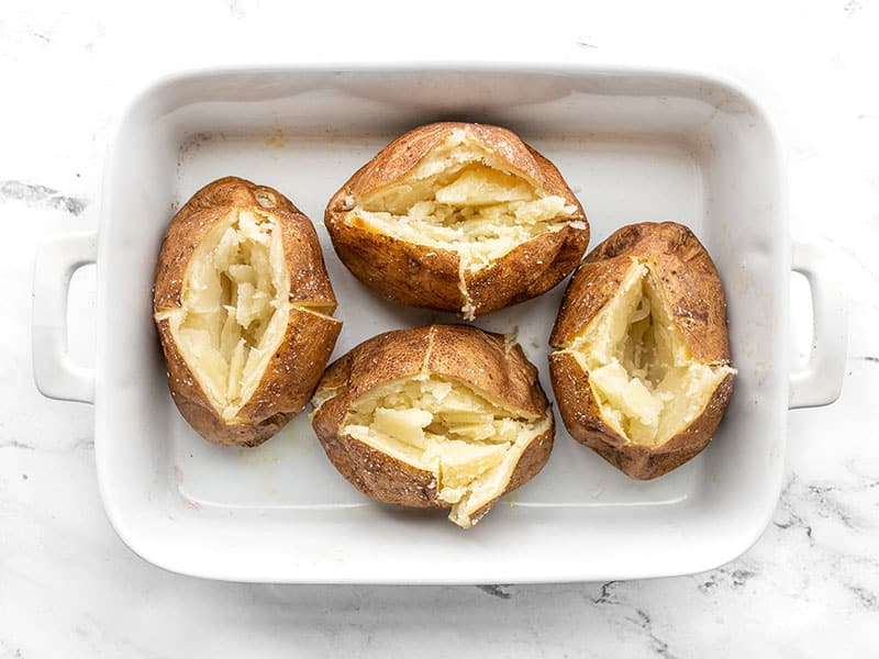 Opened baked potatoes in the casserole dish