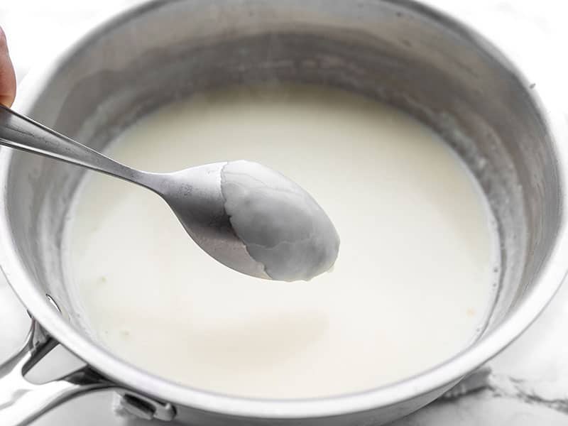 Thickened milk coating the back of a spoon