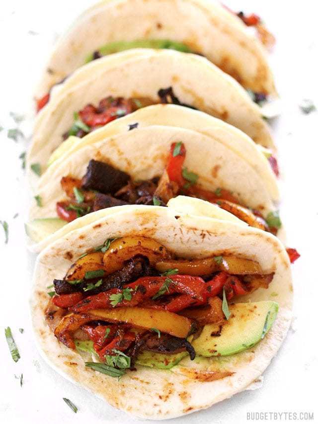 Chipotle Portobello Oven Fajitas lined up, viewed from the front, garnished with cilantro.