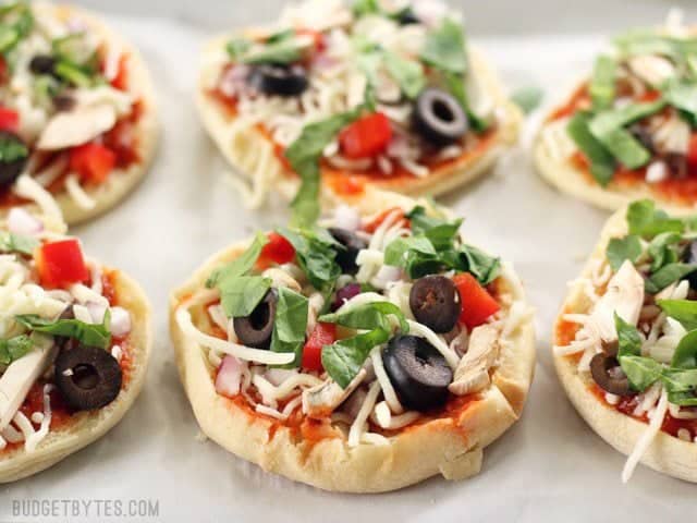 Six Freezer Mini Pizzas on a parchment lined baking sheet, ready to be frozen or baked