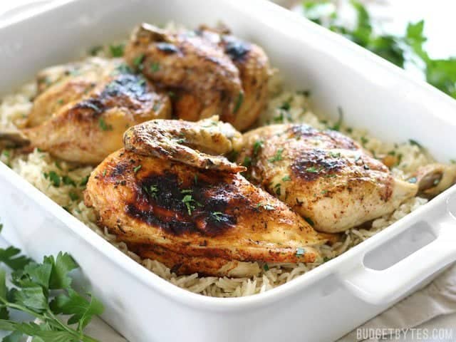 Pressure Cooker Chicken and Rice is an easy and flavorful four-ingredient dinner that leaves zero waste. Slow cooker instructions included. Budgetbytes.com Side shot of Pressure Cooker Chicken and Rice in a white casserole dish