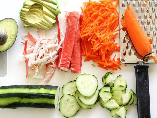 prepped vegetables for sushi bowl toppings on a cutting board
