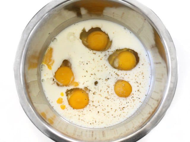 Egg, Milk, Salt, and Pepper in a metal mixing bowl