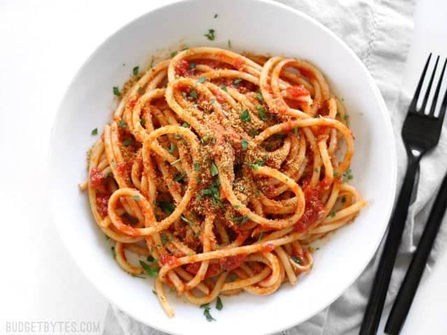 Overhead view of a bowl full of Pasta with 5 Ingredient Butter Tomato Sauce, with fork and spoon on the side.