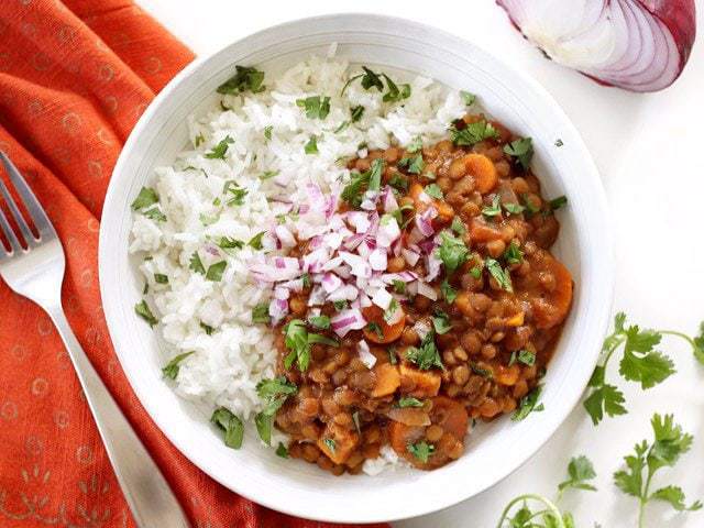 Finished bowl of Slow Cooker Coconut Curry Lentils topped with red onion and cilantro