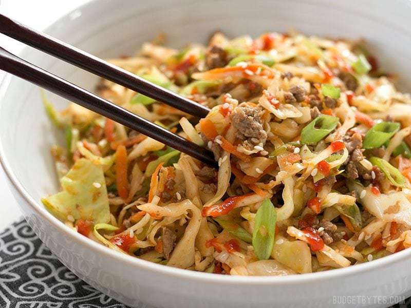 One bowl of beef and cabbage stir fry with toppings.