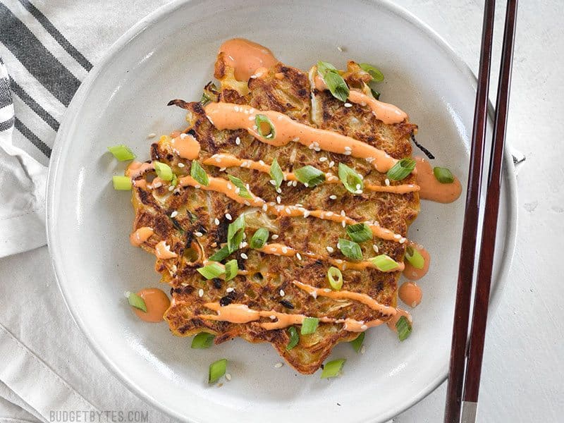 Overhead view of one Savory Cabbage Pancake with chopsticks on the side. 