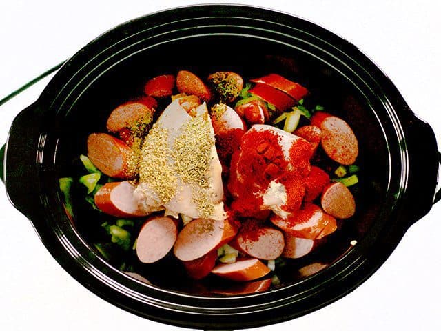 Sliced Sausage, Chicken Thighs and Spices added to slow cooker 