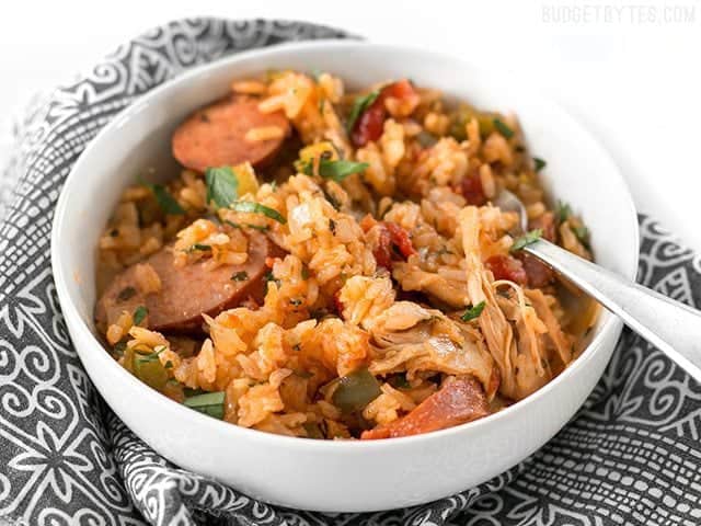 Side view of a bowl of Slow Cooker Jambalaya sitting on patterned napkin 