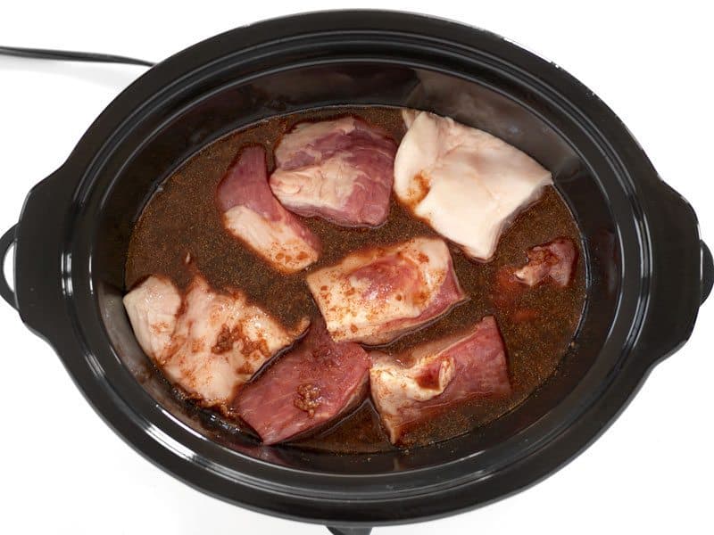 Pork cubed in slow cooker with marinade poured over top