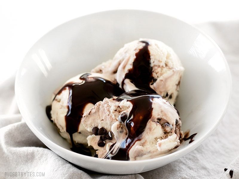 A bowl of No-Churn Mint Chocolate Chip Ice Cream with chocolate syrup on top