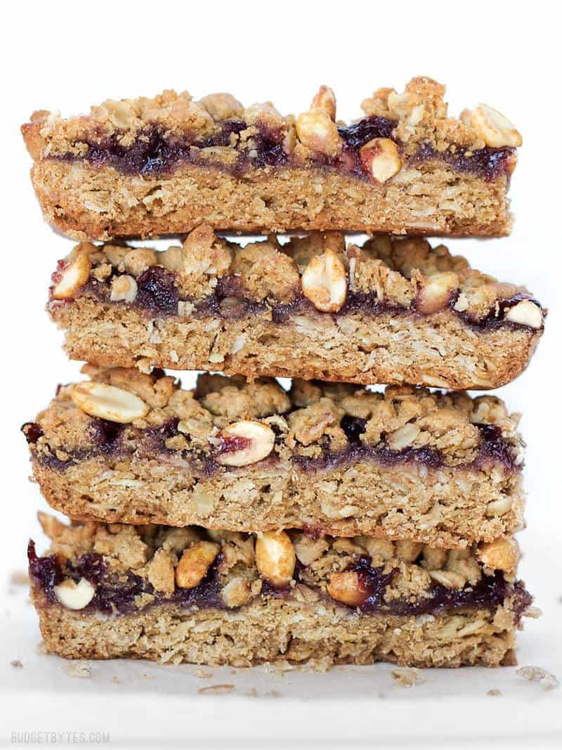 Peanut Butter and Jelly Bars are the perfect mix of salty and sweet in a dessert that will remind you of your childhood. BudgetBytes.com Side view of a stack of Peanut Butter and Jelly Bars