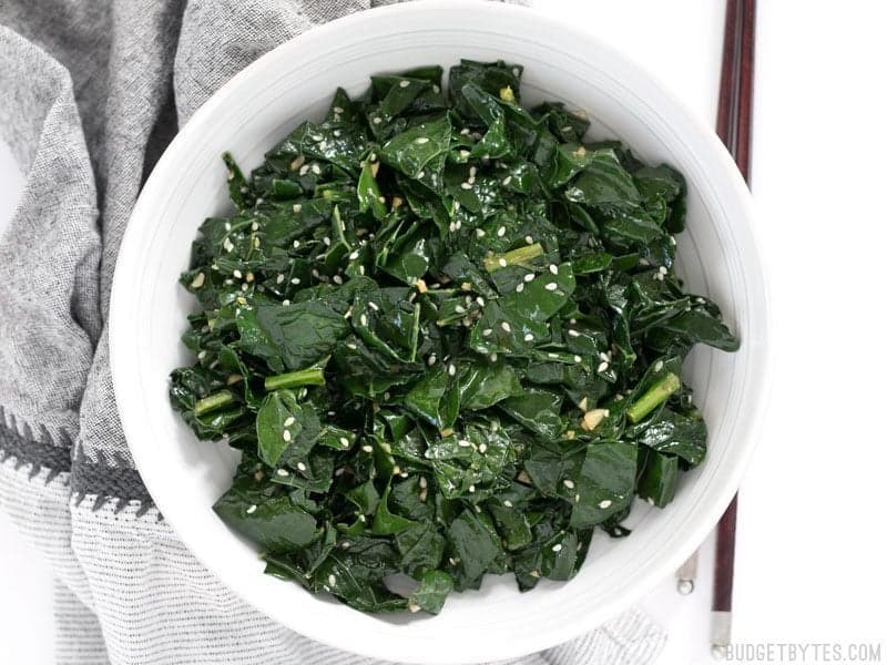 Finished Sesame Kale in a bowl with chopsticks on the side