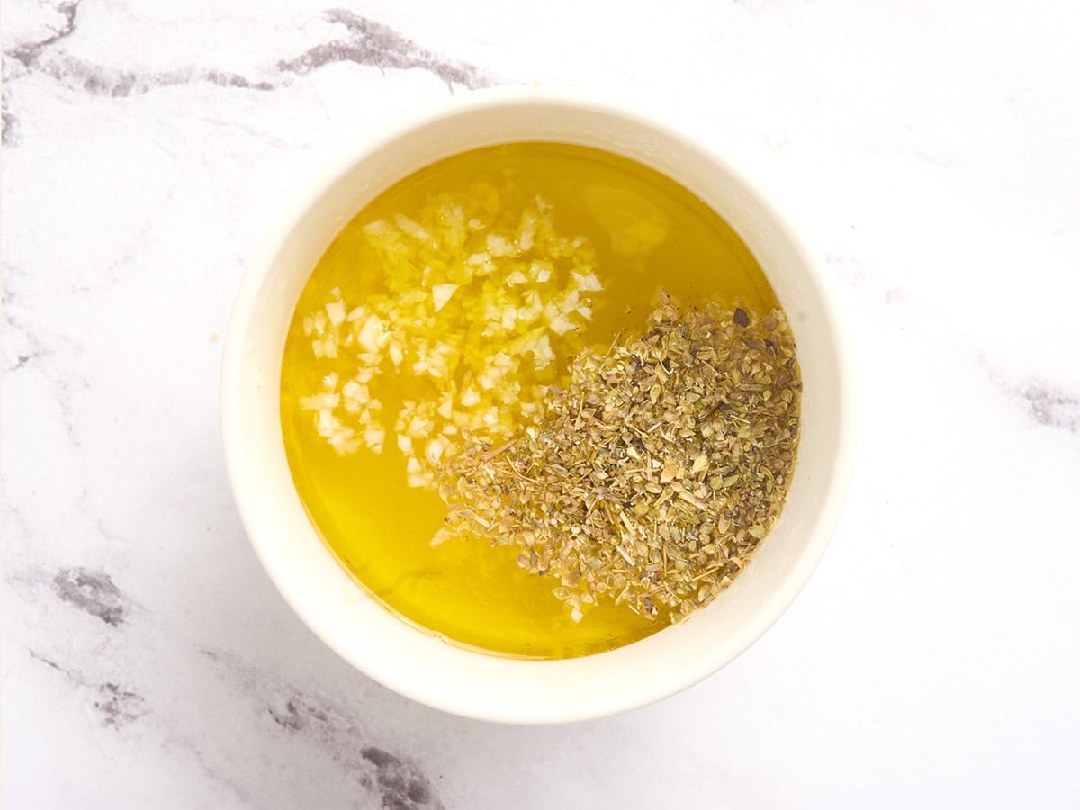The ingredients to make a lemon garlic dressing in a bowl.