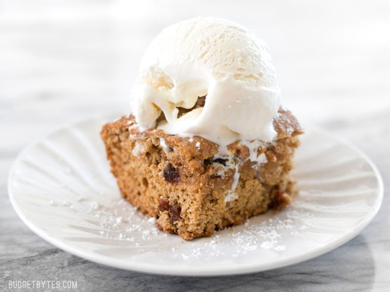 Close up of one square of Applesauce Cake with a scoop of vanilla ice cream on top.