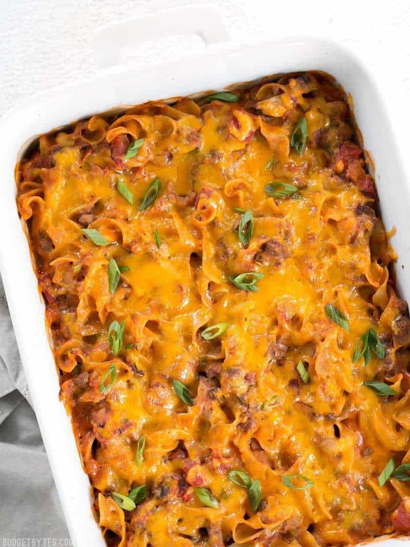 Overhead view of a Beef & Mushroom Country Casserole in a white rectangular casserole dish, garnished with green onion