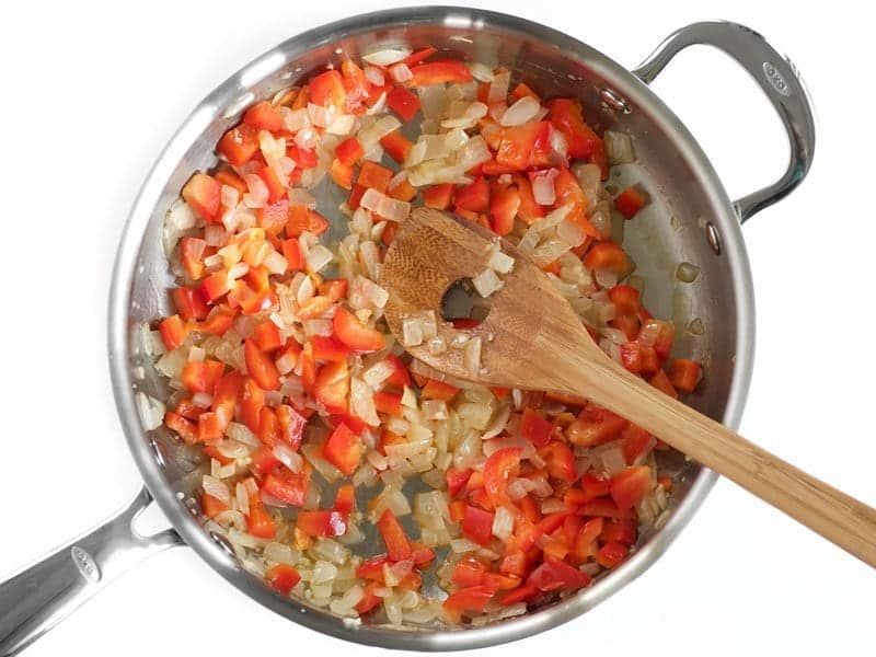 Diced Red bell Pepper added to sautéed onion in skillet