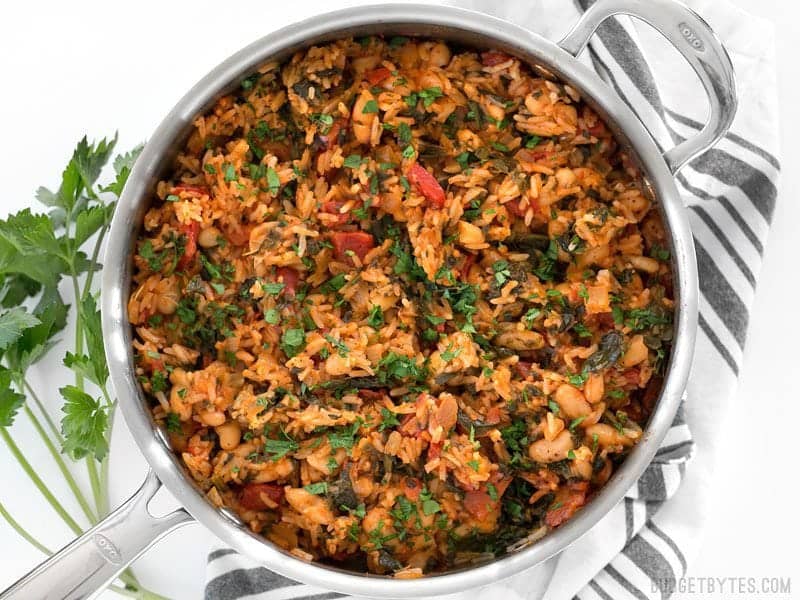 Finished Tomato Herb Rice with White Beans and Spinach in the skillet on a striped napkin