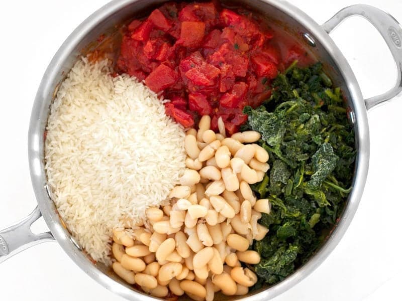 Tomatoes Spinach White Beans and Rice added to the skillet