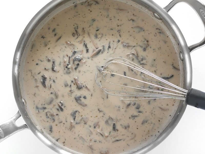 Whisked Creamy Mushroom Herb Sauce in the skillet with whisk
