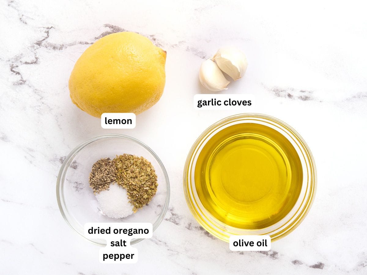 The ingredients to make a lemon garlic salad dressing with labels.