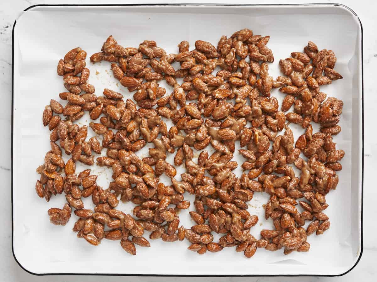 Almonds spread out onto a baking sheet lined with parchment paper. 