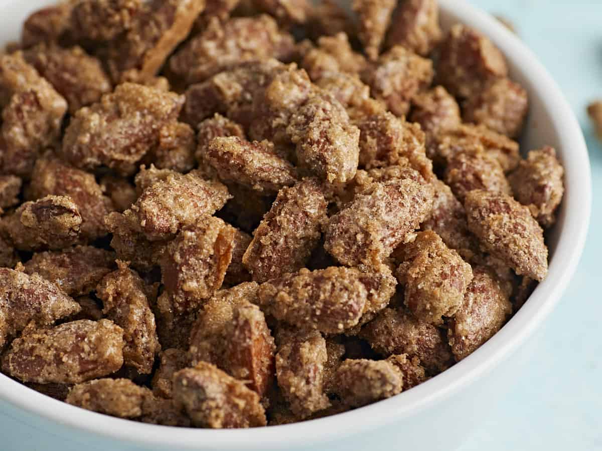 Close up side view of candied almonds in a bowl. 