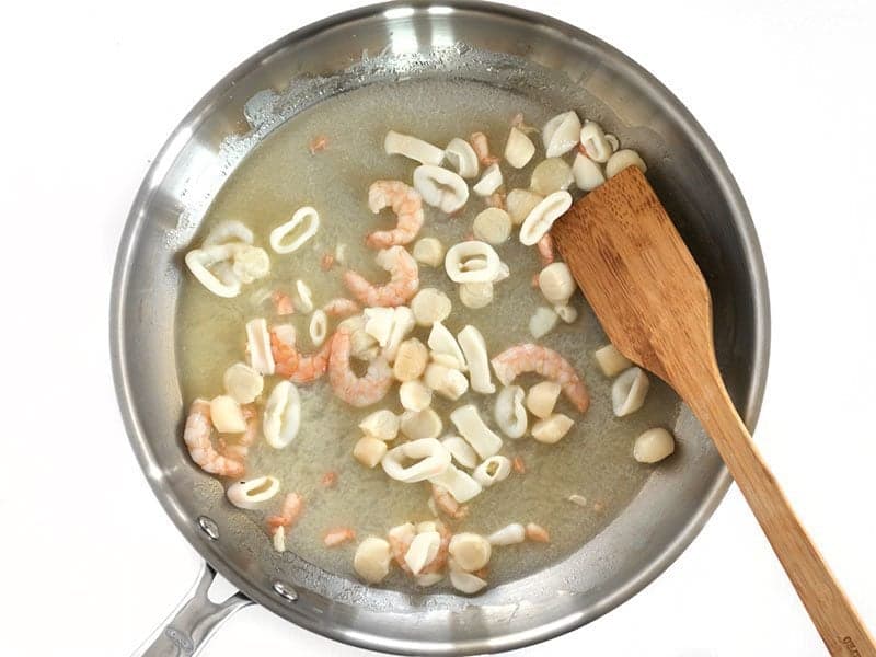 Seafood Mix being cooked with butter in the skillet.