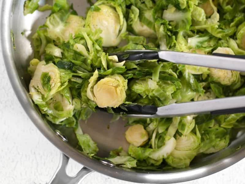 Sauté Shaved Brussels Sprouts, in the skillet with tongs