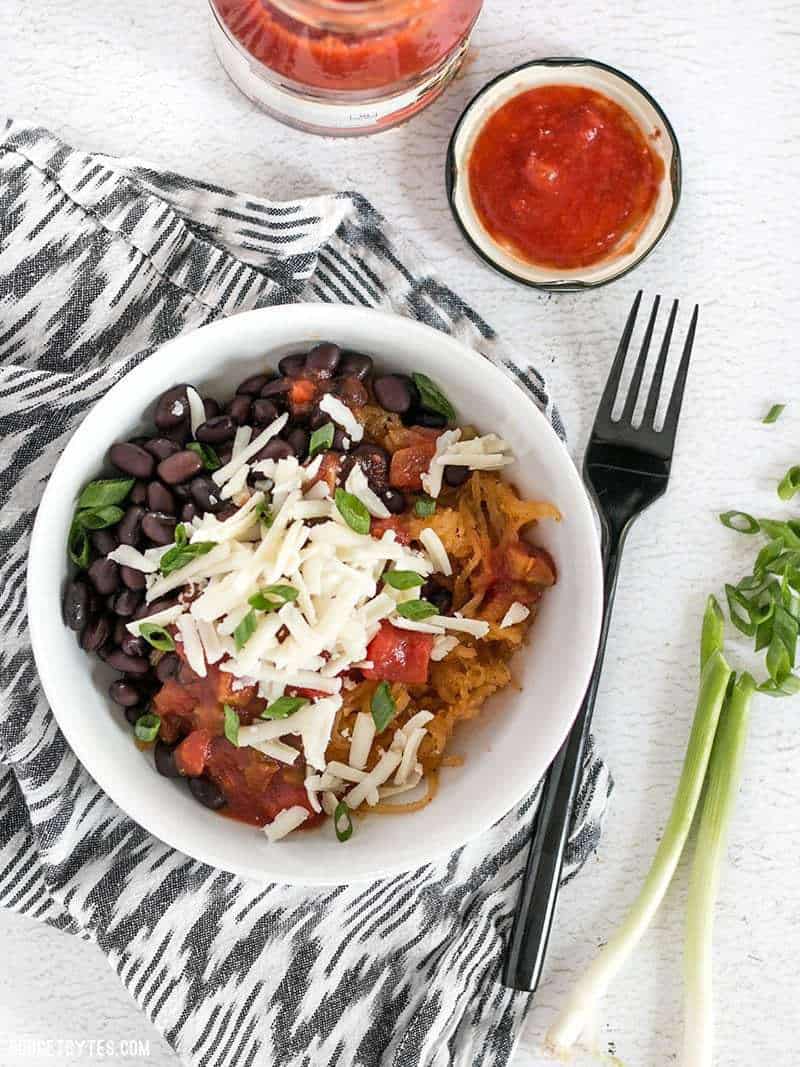 Spaghetti squash makes a great fiber-filled low-carb substitute for rice in these Southwest Spaghetti Squash Bowls. BudgetBytes.com A southwest spaghetti squash bowl on a striped napkin with a jar of salsa nearby and a sliced green onion on the side.