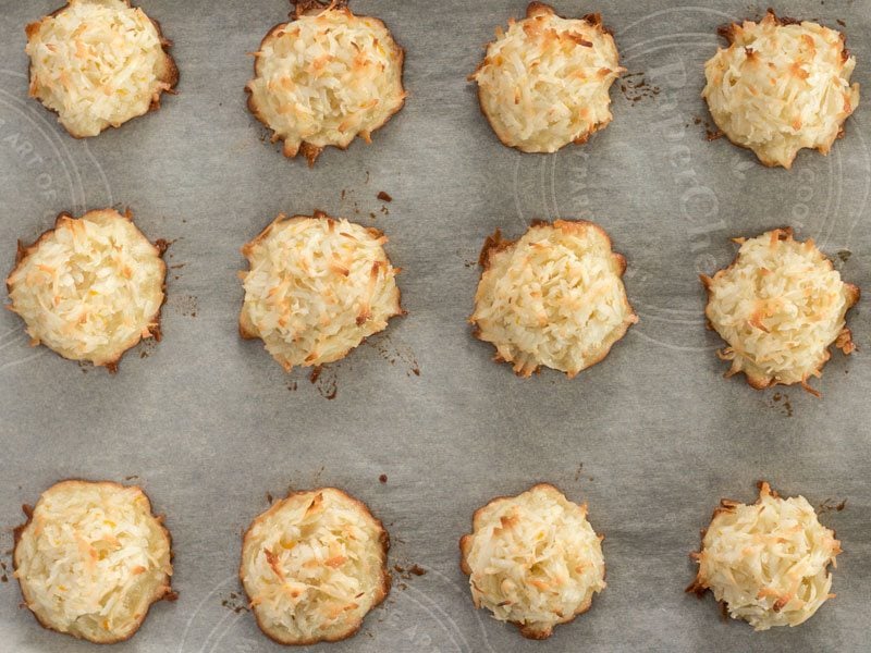 Baked Macaroons on a parchment lined baking sheet, viewed from above