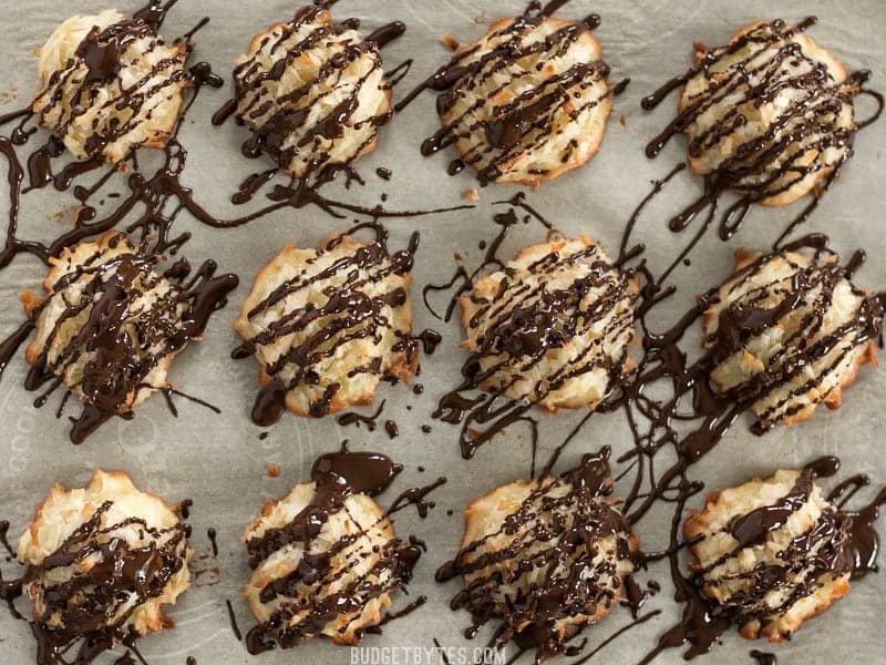 Finished Chocolate Glazed Macaroons on a parchment lined baking sheet, viewed from above
