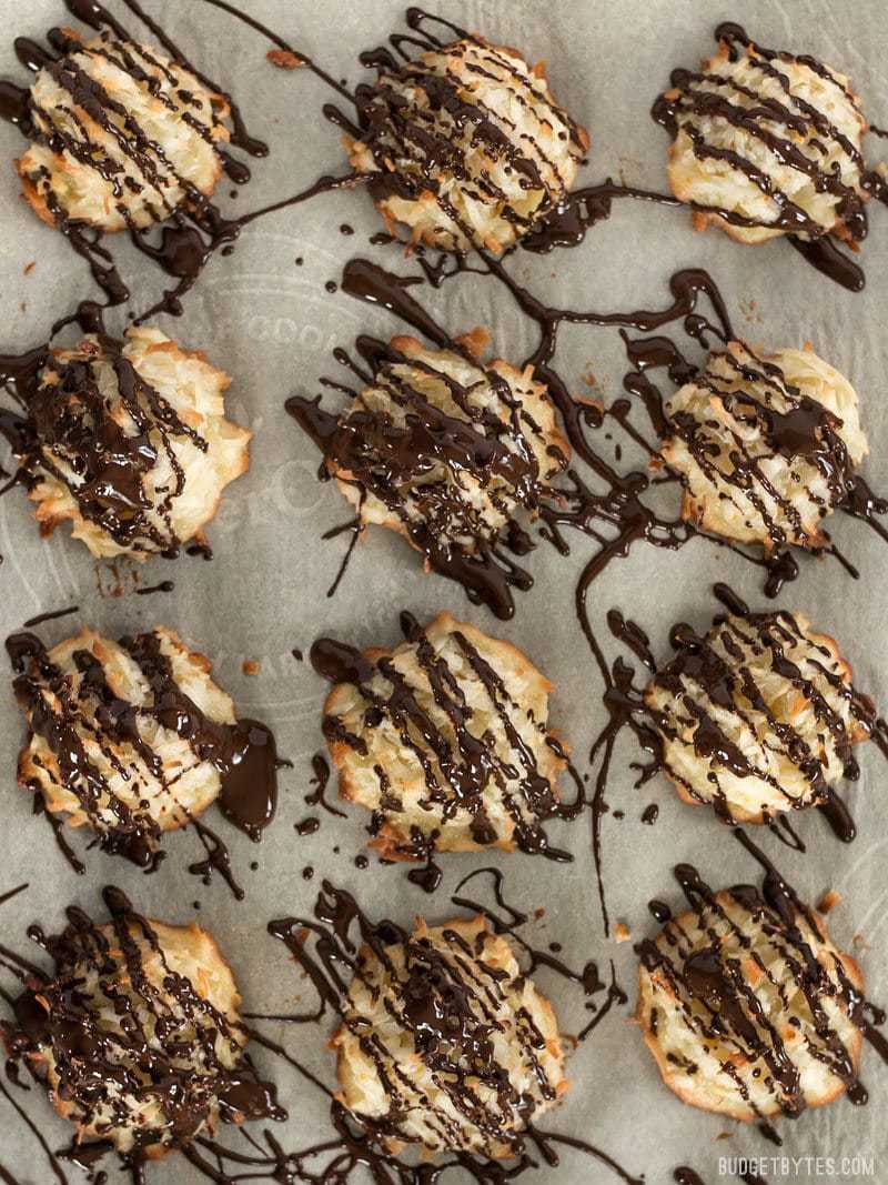 Finished Chocolate Glazed Macaroons on a parchment lined baking sheet, viewed from above