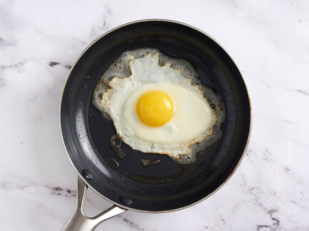 An egg frying in a skillet.