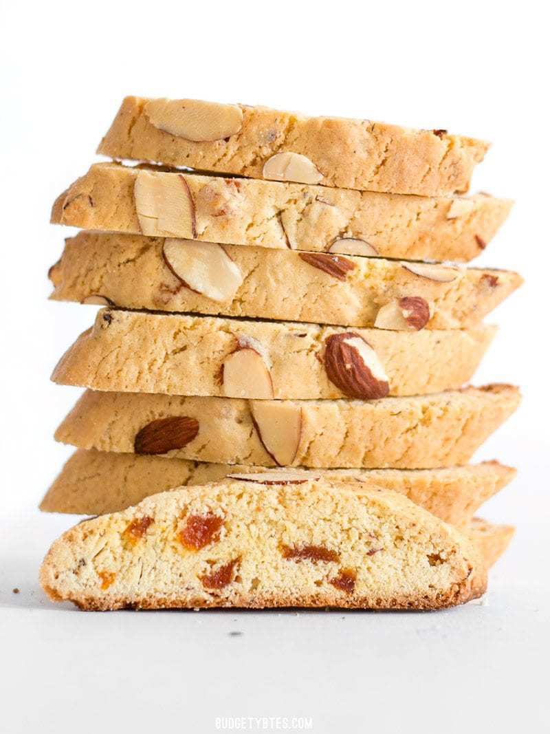 A stack of homemade Almond Apricot Biscotti with one sitting in front facing the camera