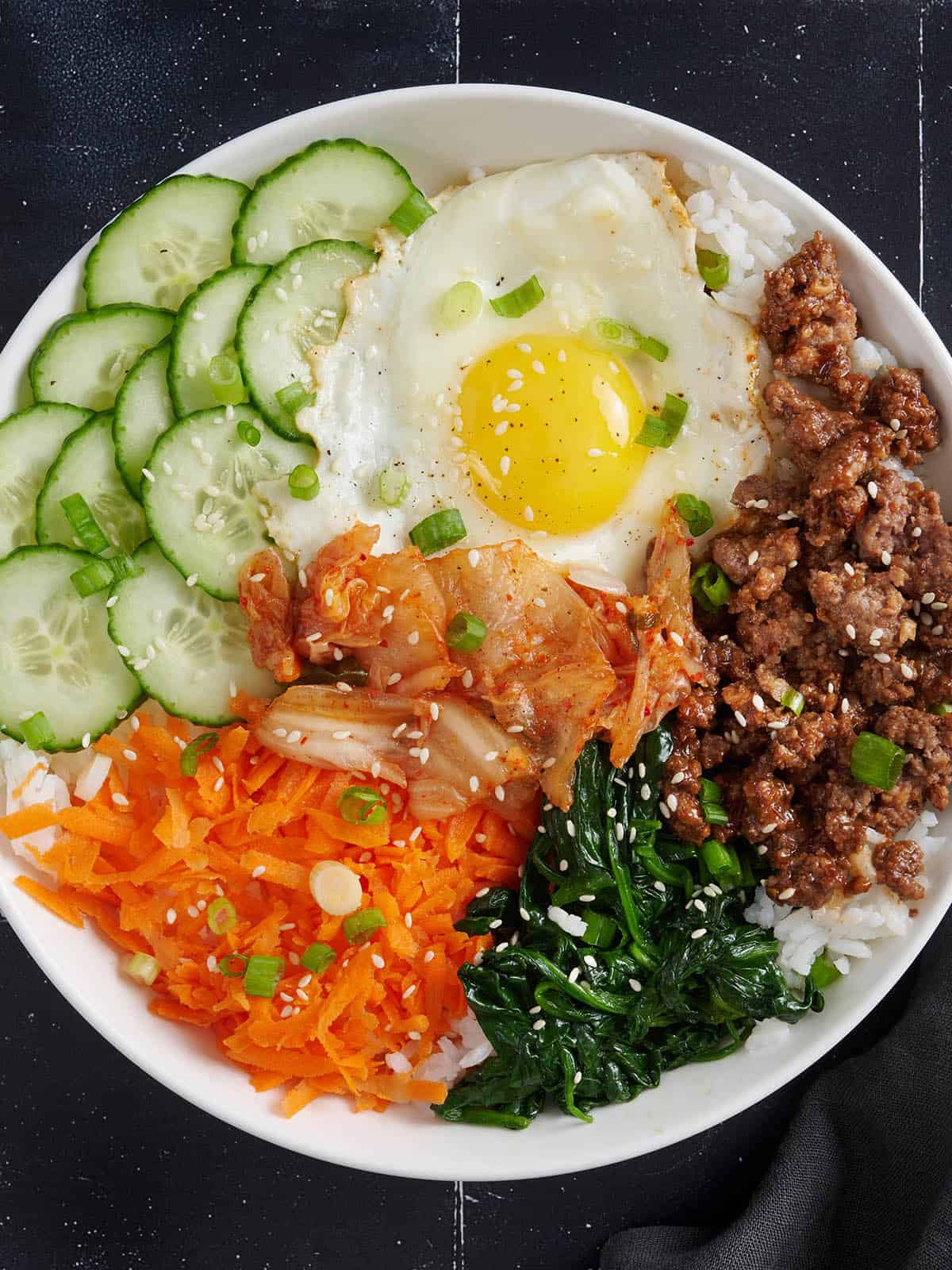 Bibimbap is the ultimate bowl meal with plenty of color, flavor, and texture to keep your taste buds happy and your stomach full. BudgetBytes.com Overhead view of a bibimbap bowl meal.