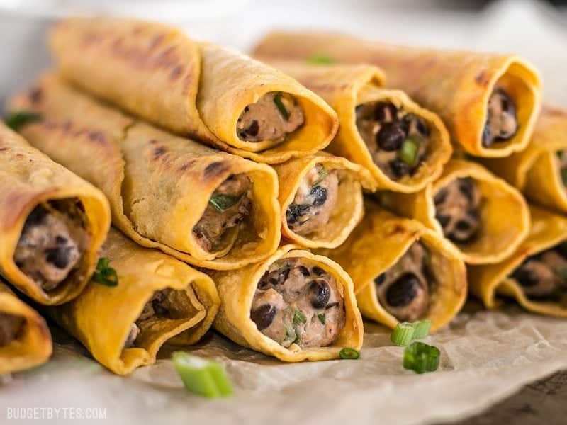 Close up side view of a stack of Creamy Black Bean Taquitos so the filling is visible 