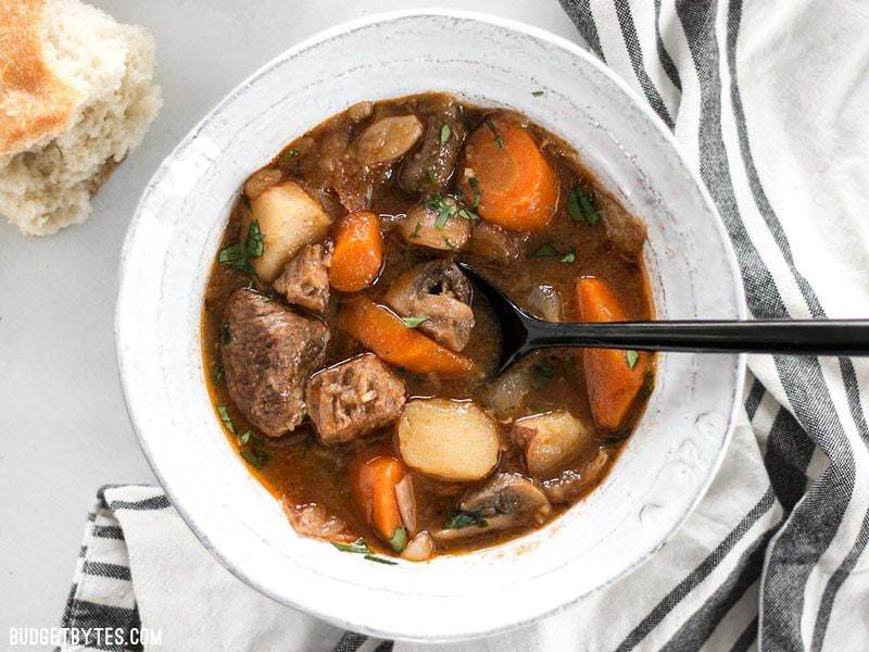 Overhead shot of a bowl of Instant Pot Beef Stew with bread on the side
