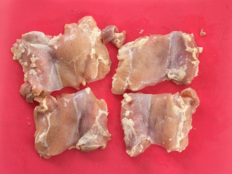 Raw Chicken Thighs seasoned with salt and pepper
