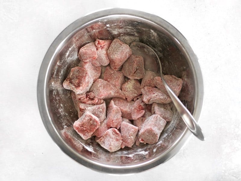 Season Stew Meat coated in flour in a bowl