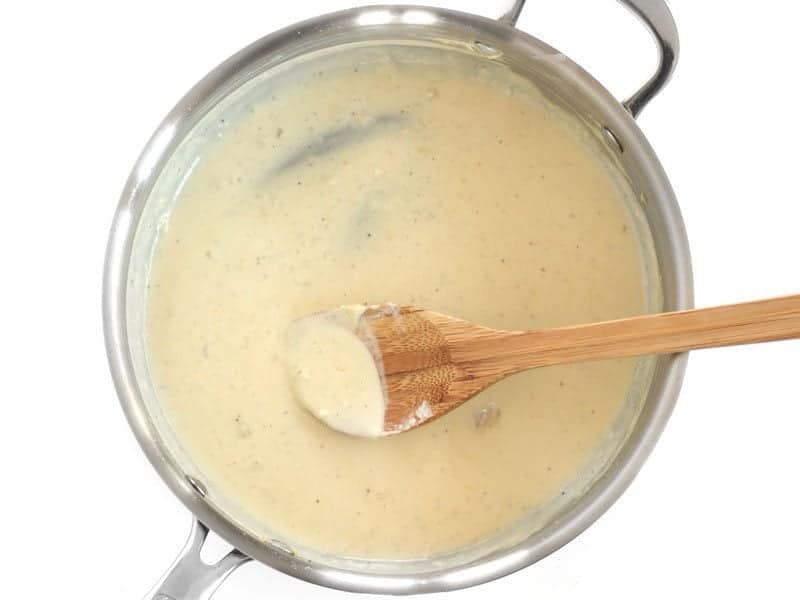 Thickened Sauce in the skillet, on a wooden spoon