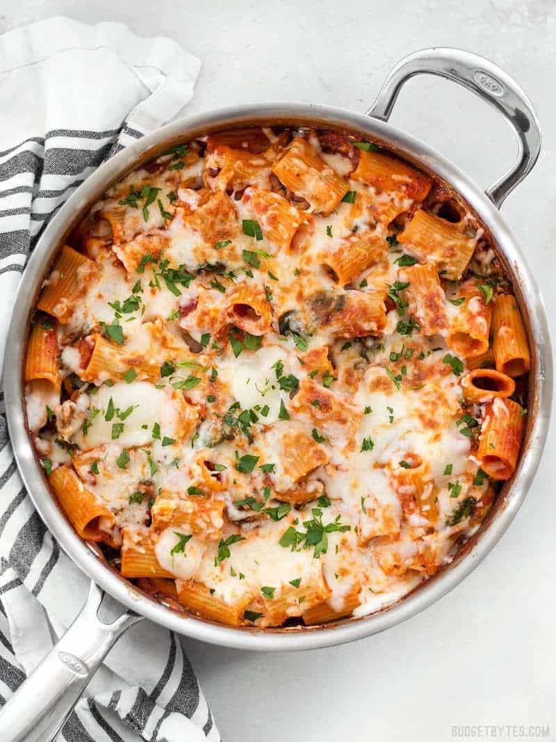Overhead view of A skillet full of Cheesy Rigatoni garnished with parsley