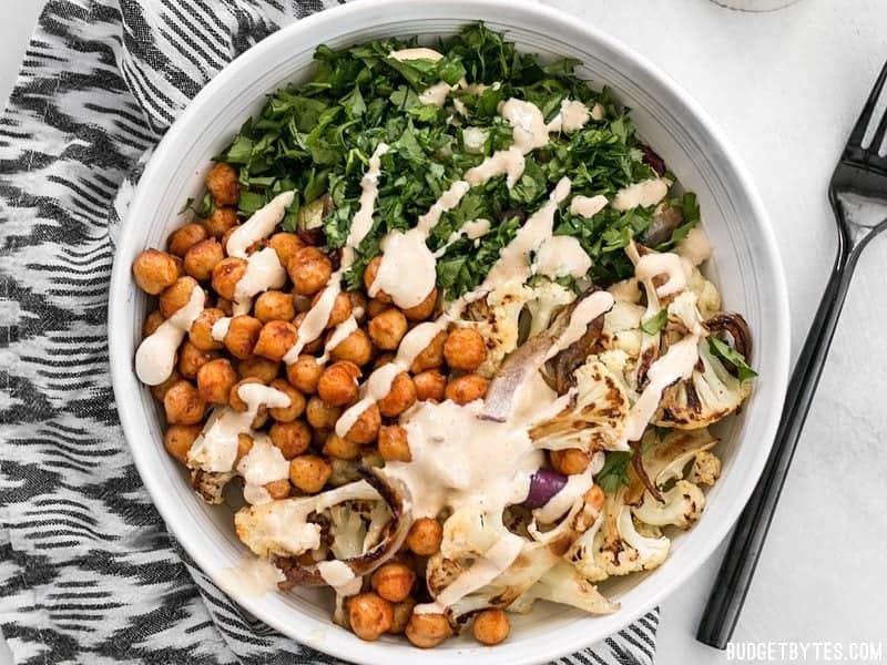 A bowl of Roasted Cauliflower Salad with lemon tahini dressing drizzled over top