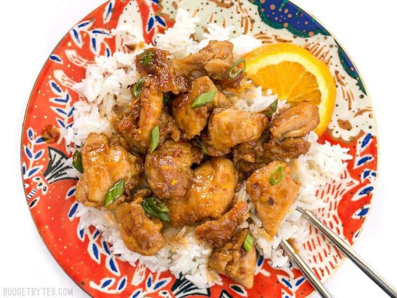 This Easy Orange Chicken cooks quickly in a skillet (no deep frying!) and uses only real, fresh ingredients. It's the perfect take-out fake-out. BudgetBytes.com Overhead view of a plate of easy orange chicken with rice.