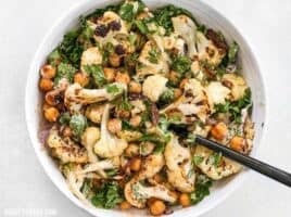 This Roasted Cauliflower Salad combines sweet roasted red onions, spiced chickpeas, tender cauliflower, and a tangy lemon tahini dressing. BudgetBytes.com