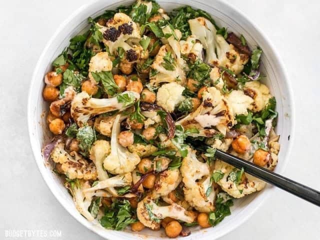 This Roasted Cauliflower Salad combines sweet roasted red onions, spiced chickpeas, tender cauliflower, and a tangy lemon tahini dressing. BudgetBytes.com