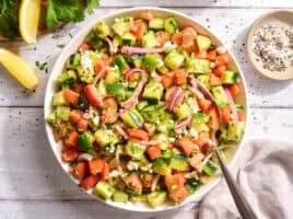 Overhead view of a bowl of cucumber tomato salad.